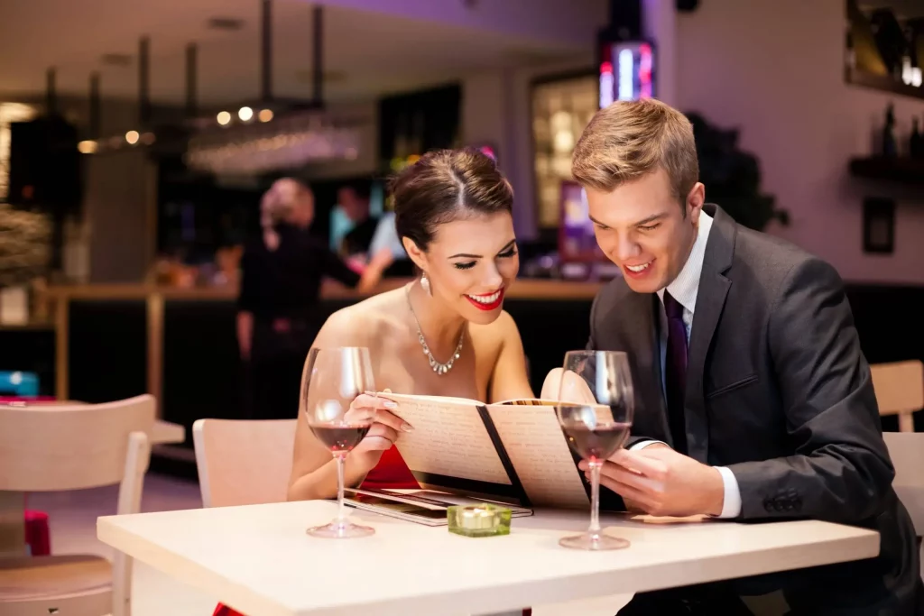 A young man is dating an older woman and they are having dinner together.