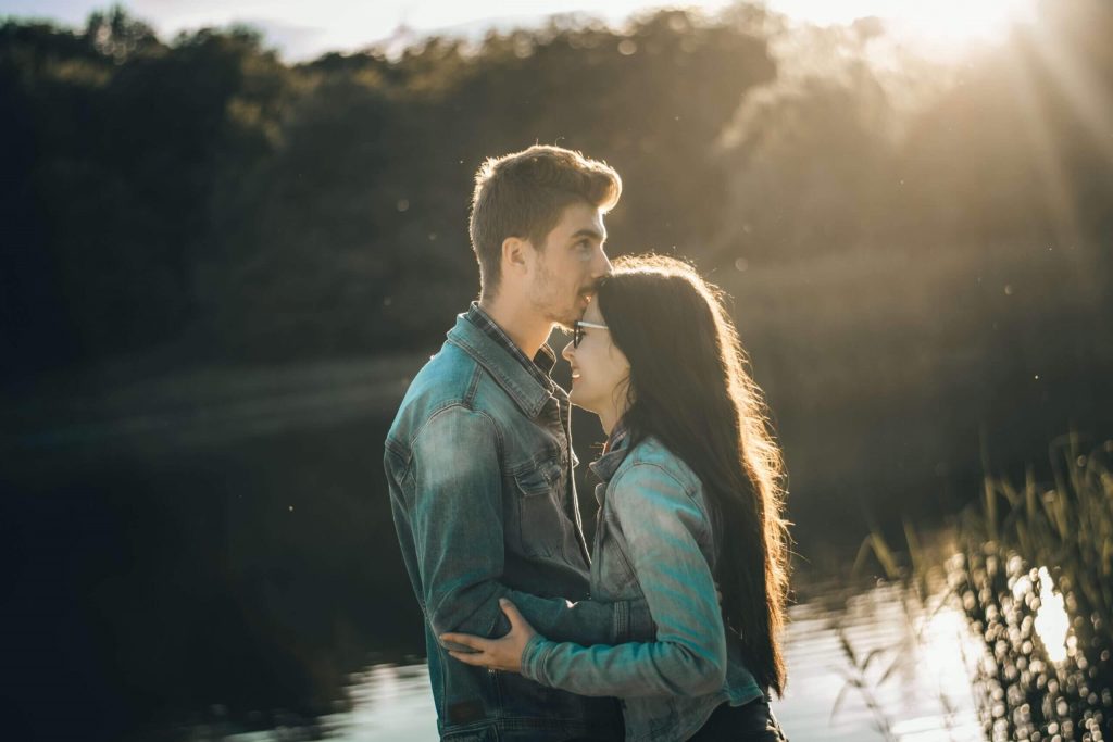 man kissing woman forehead